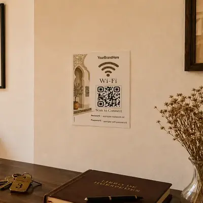 Papan QR code WiFi berbingkai di dinding lobi guest house